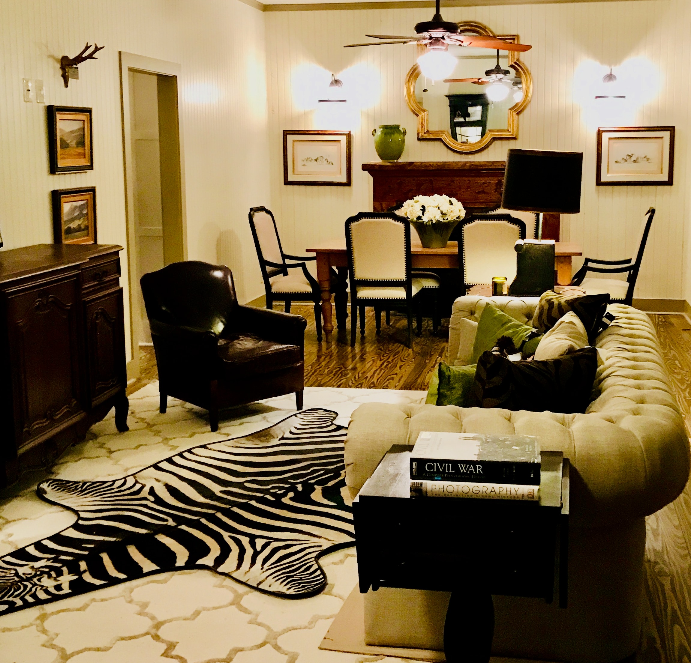 Warm living room with tufted sofa, zebra rug, and classic furnishings styled by Deborah Martin Design