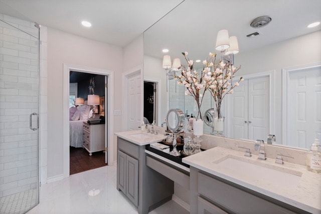 Bathroom after renovation — refined grey cabinetry, marble tile, and elegant lighting