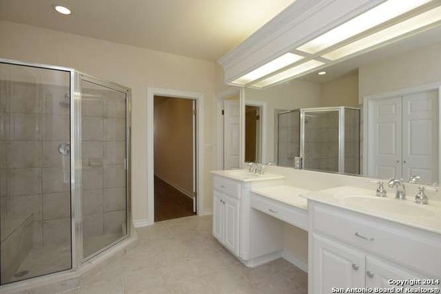 Bathroom before renovation — dated tile and builder-grade vanity