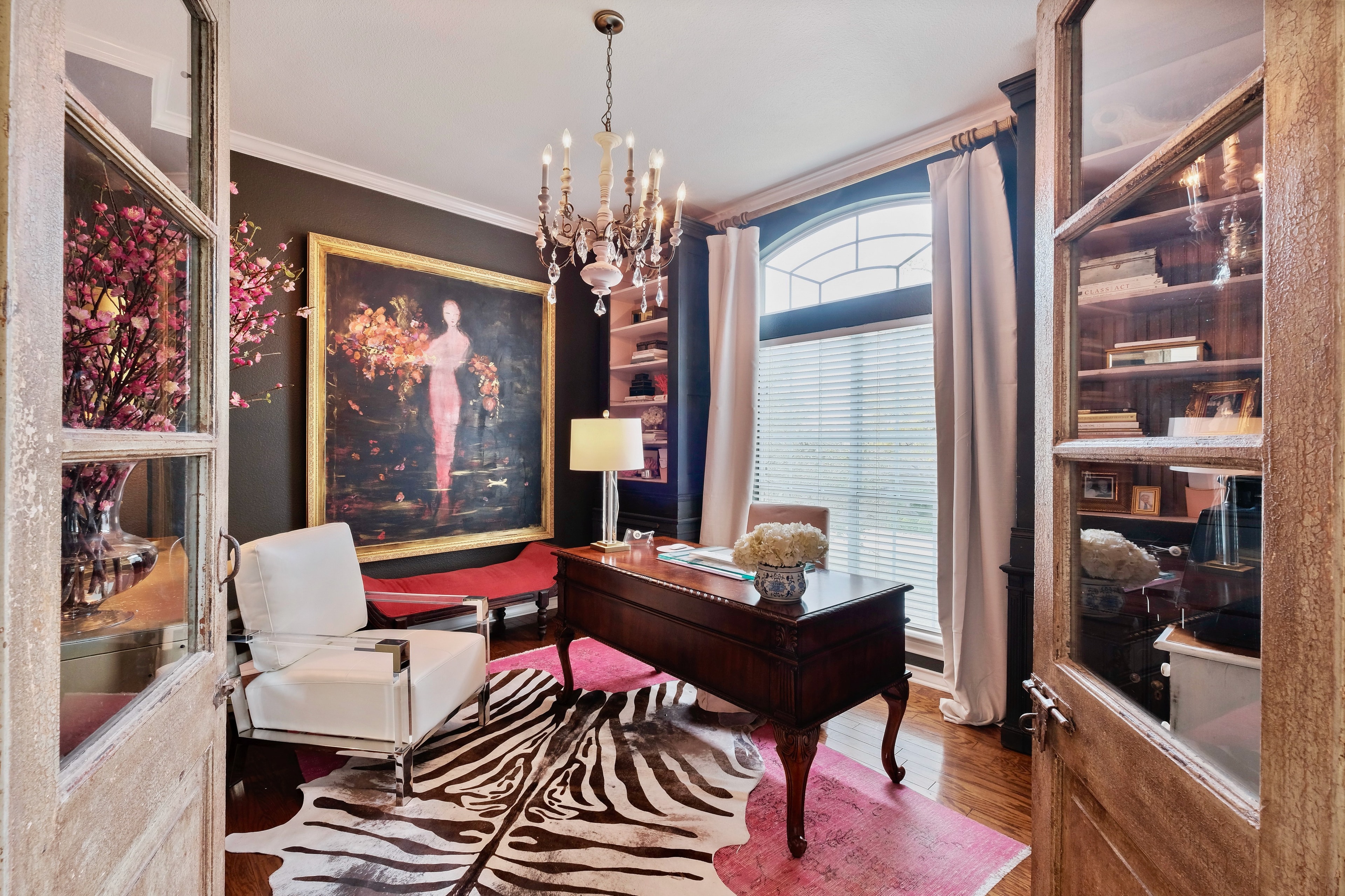 Dining room after — styled with tufted bench, crystal chandelier, navy drapery, and orchid centerpiece