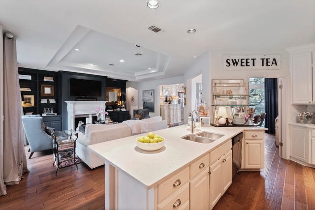 Kitchen after — refined open-plan kitchen with white island, Sweet Tea signage, and warm hardwood floors