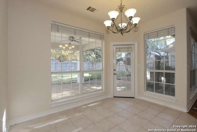 Breakfast nook before — bare tile floors and plain chandelier
