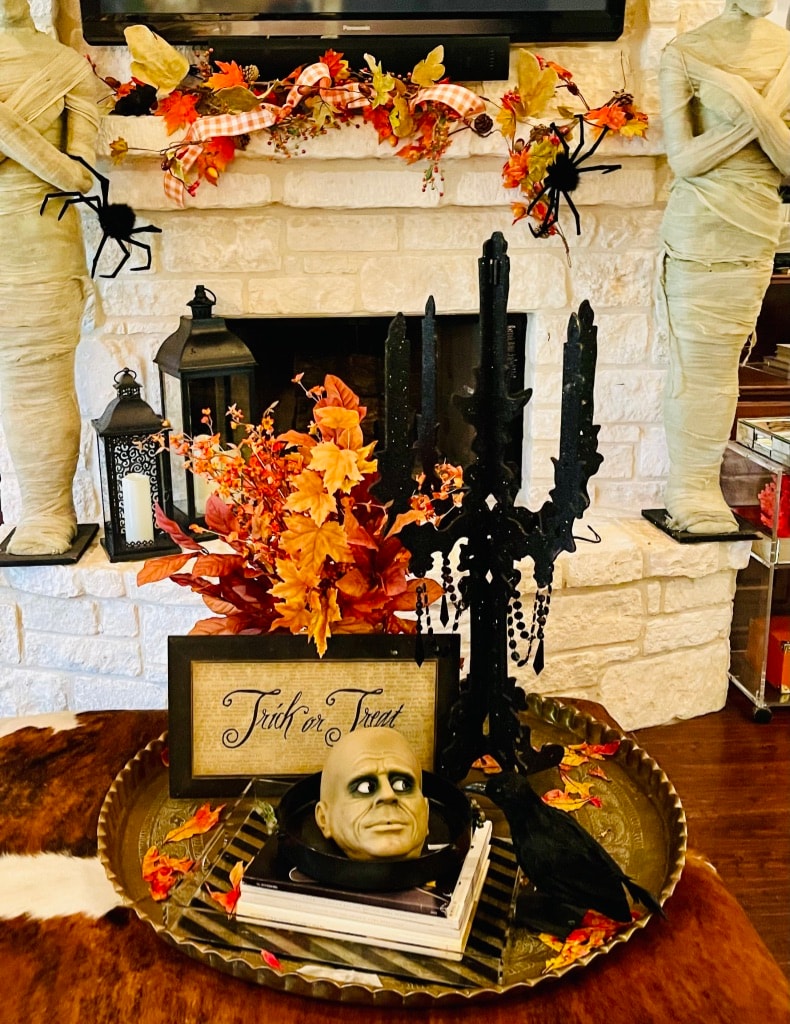 Halloween fireplace display with black candelabra, Trick or Treat sign, and fall garland